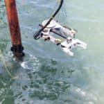 Photo of underwater guillotine cutter lowered into the ocean via crane